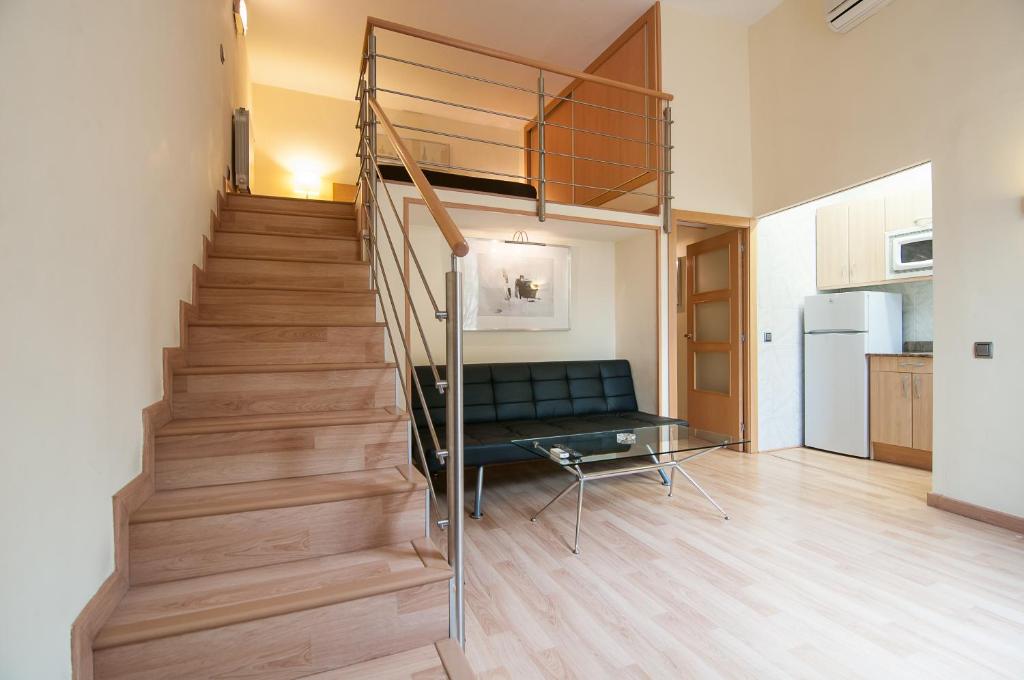 sala de estar con escalera y sofá en Alos Apartments Paseo de Gracia-Diagonal en Barcelona