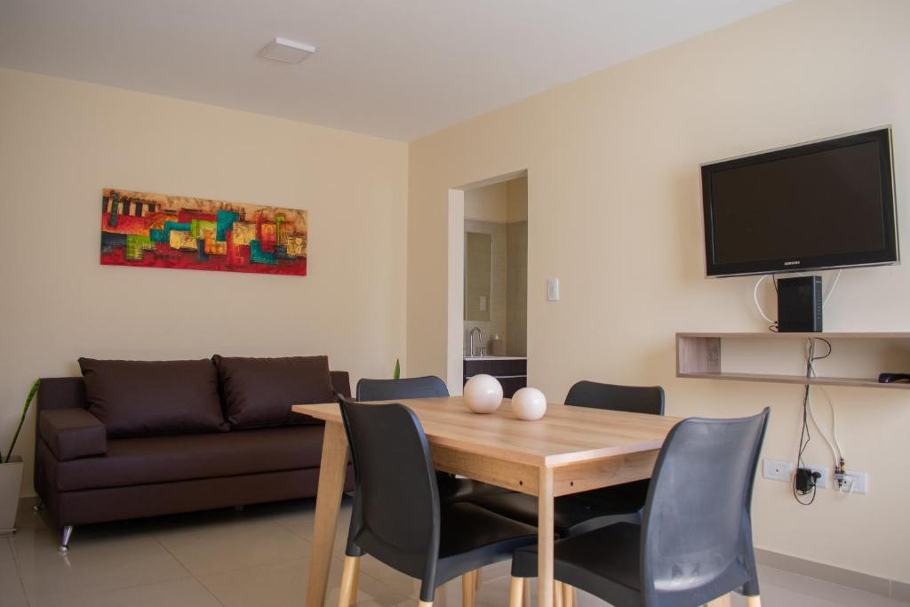 sala de estar con mesa y sofá en Departamento Solares de Cofico - Terraza Privada en Córdoba