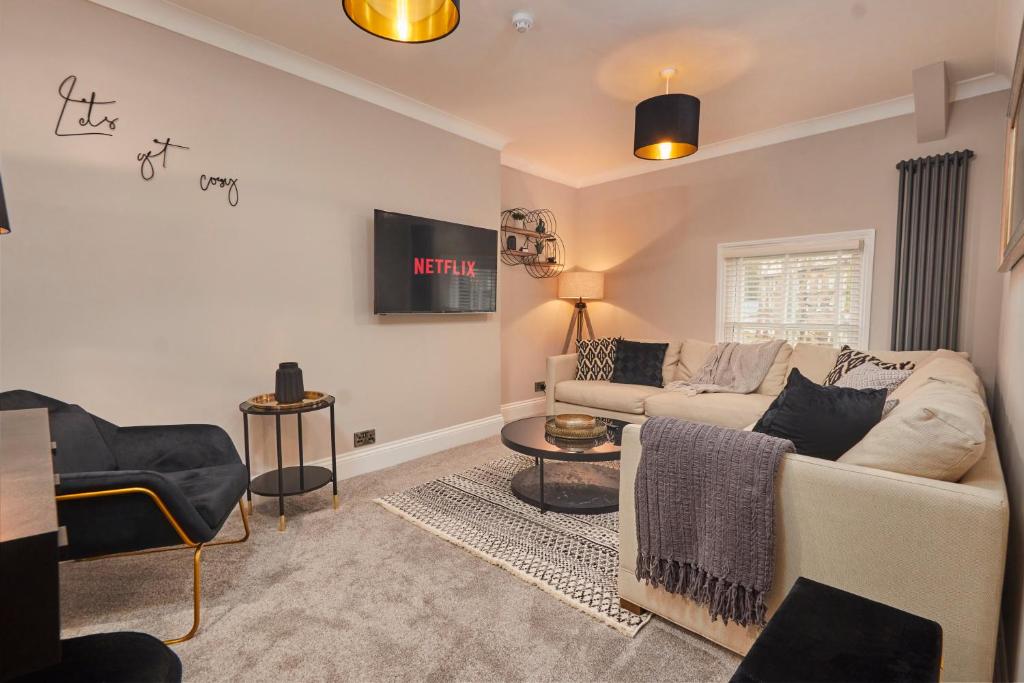 a living room with a couch and a tv at The Swan Apartment - Free parking in Harrogate