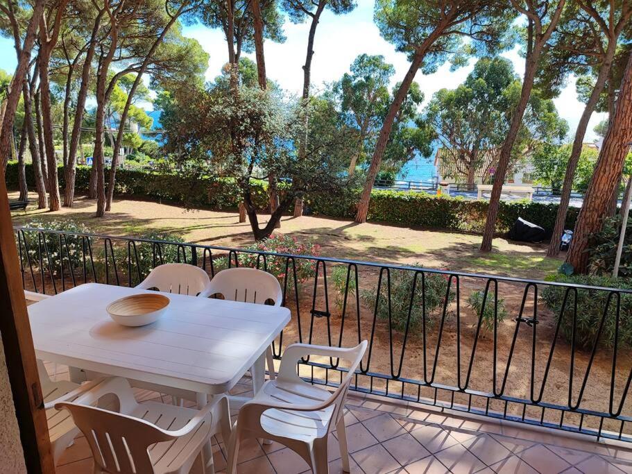uma mesa branca e cadeiras numa varanda em Apartamento con VISTAS AL MAR y jardín a 150 metros de la playa em Sant Antoni de Calonge
