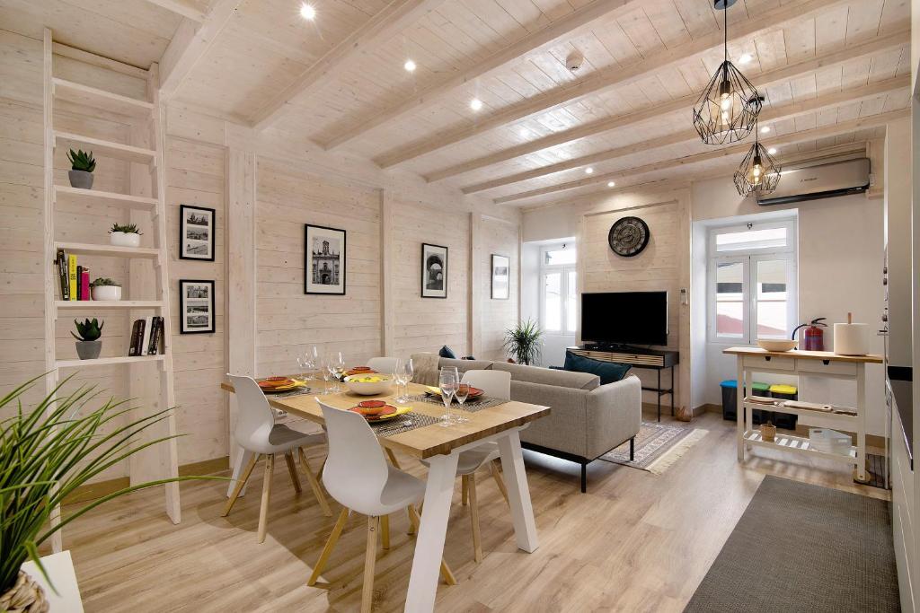 - une salle à manger et un salon avec une table et des chaises dans l'établissement Casa na Travessa, à Faro