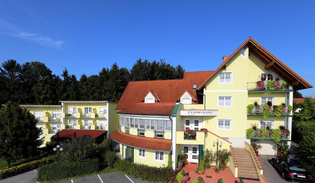 ein großes gelbes Gebäude mit rotem Dach in der Unterkunft Panoramahof Ziegler in Bad Waltersdorf