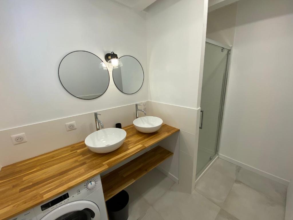łazienka z 2 umywalkami i lustrem w obiekcie Maisonnette confortable à Pornic w mieście Pornic