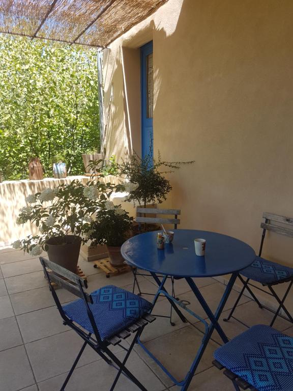 a blue table and chairs on a patio at La Colline Bleue in Banne