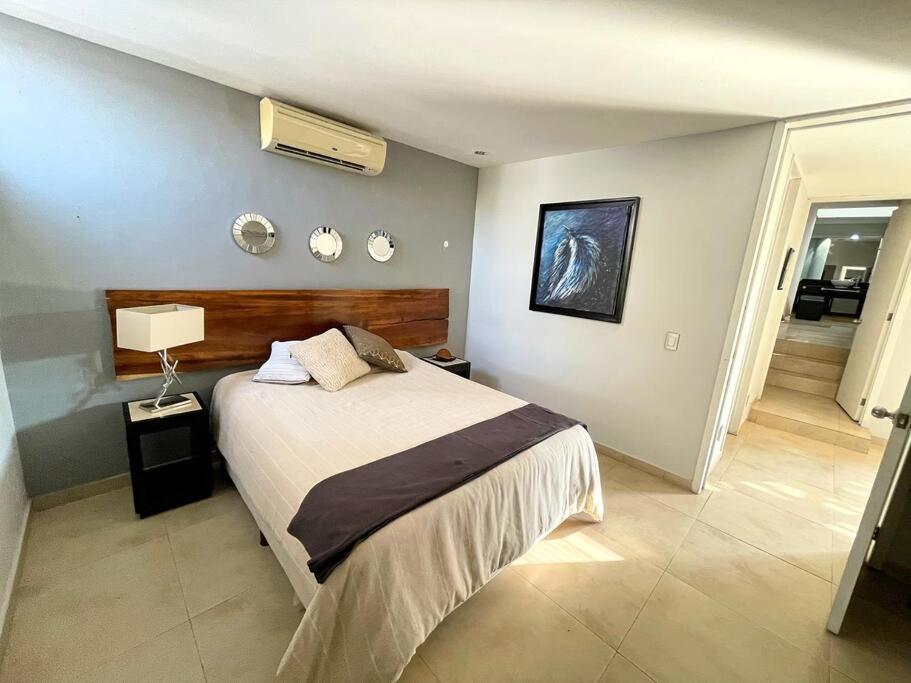 ein Schlafzimmer mit einem großen Bett und einem Flur in der Unterkunft MODERNO Y ARTISTICO EN GUADALAJARA in Guadalajara