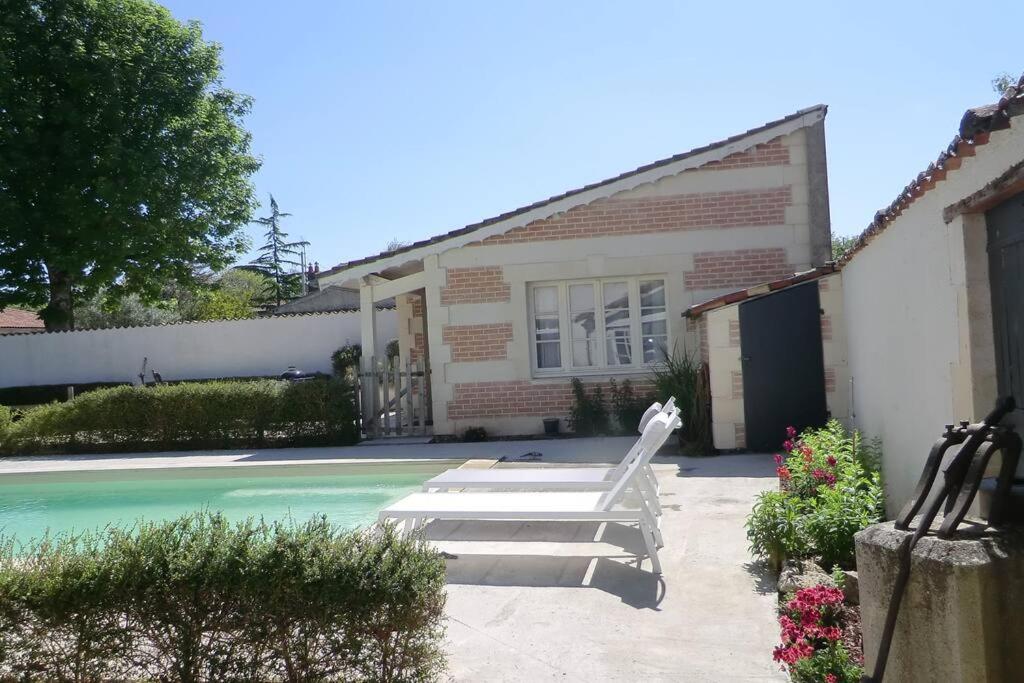 una casa con piscina al lado de una casa en Gîte Lachevalle, en Saint-Jean-dʼAngély
