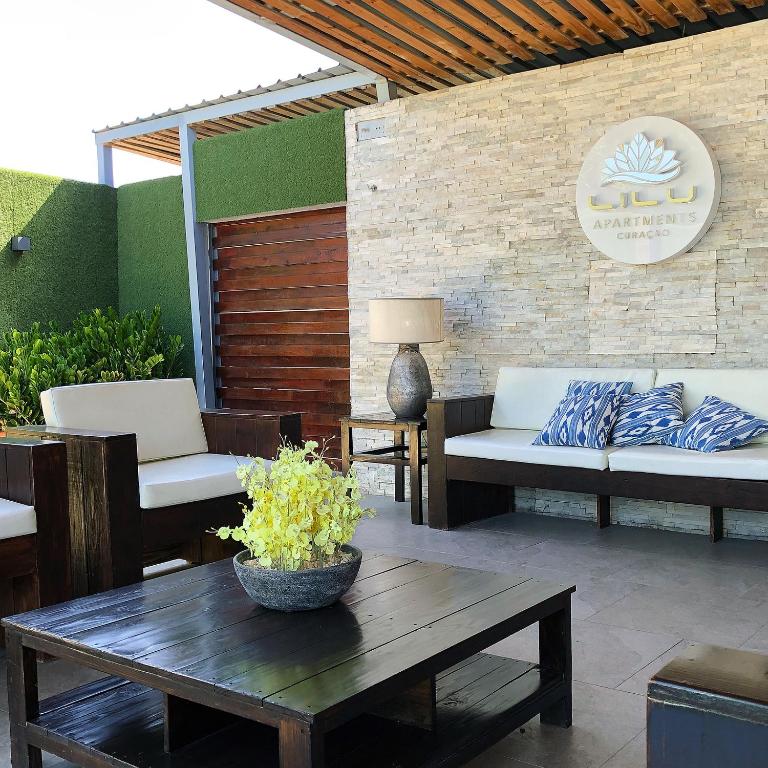 un patio con 2 sofás, una mesa y una sidra de mesa en Lilu Apartments Curaçao, en Willemstad
