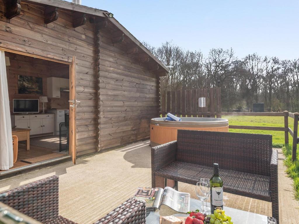 a patio with a table and chairs and a hot tub at Dukes Wood - Ukc2193 in Caunton