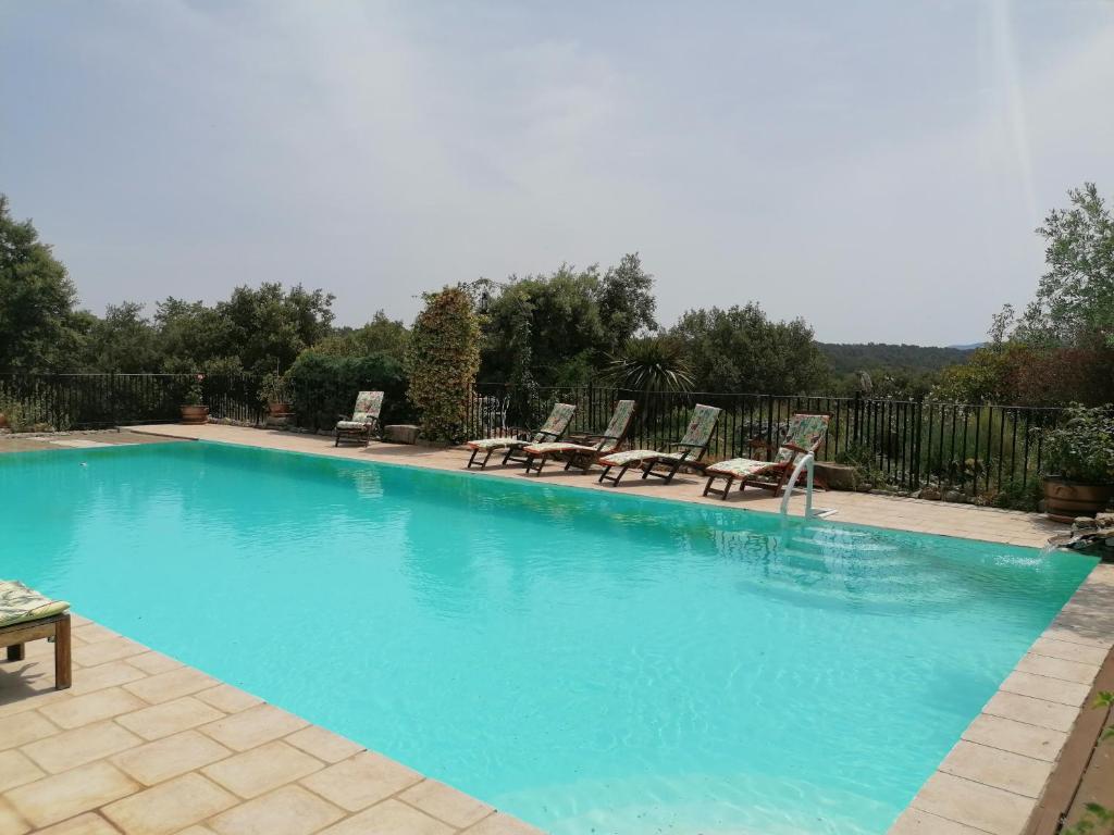 une grande piscine avec des chaises dans l'établissement Entre Ciel et Terre, à Besse-sur-Issole
