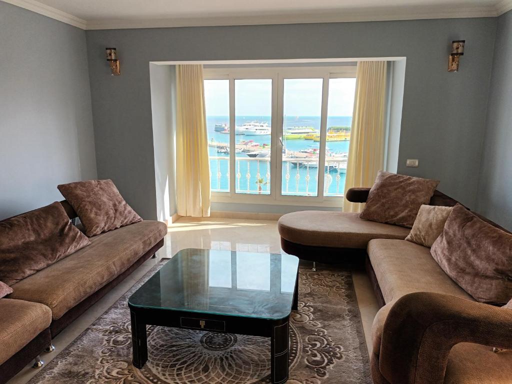 Hurghada Marina في الغردقة: غرفة معيشة مع كنب وطاولة قهوة زجاجية