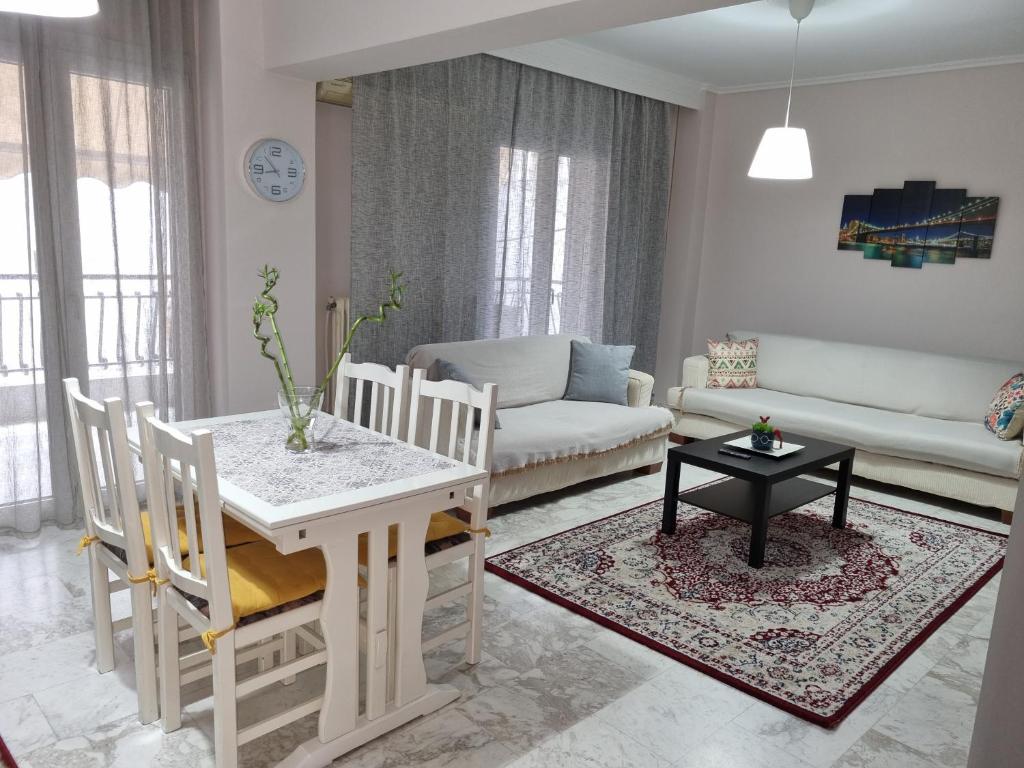 ein Wohnzimmer mit einem weißen Tisch und Stühlen in der Unterkunft Anthi's luxury home in Thessaloniki