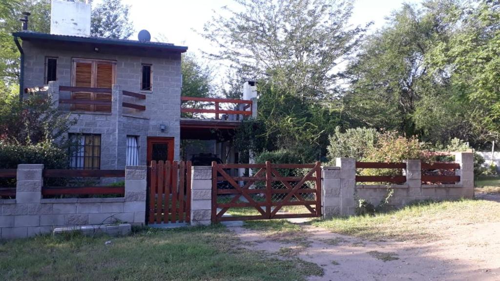 una casa con una valla y una puerta en Cabaña en las sierras de Cosquín PB en Cosquín