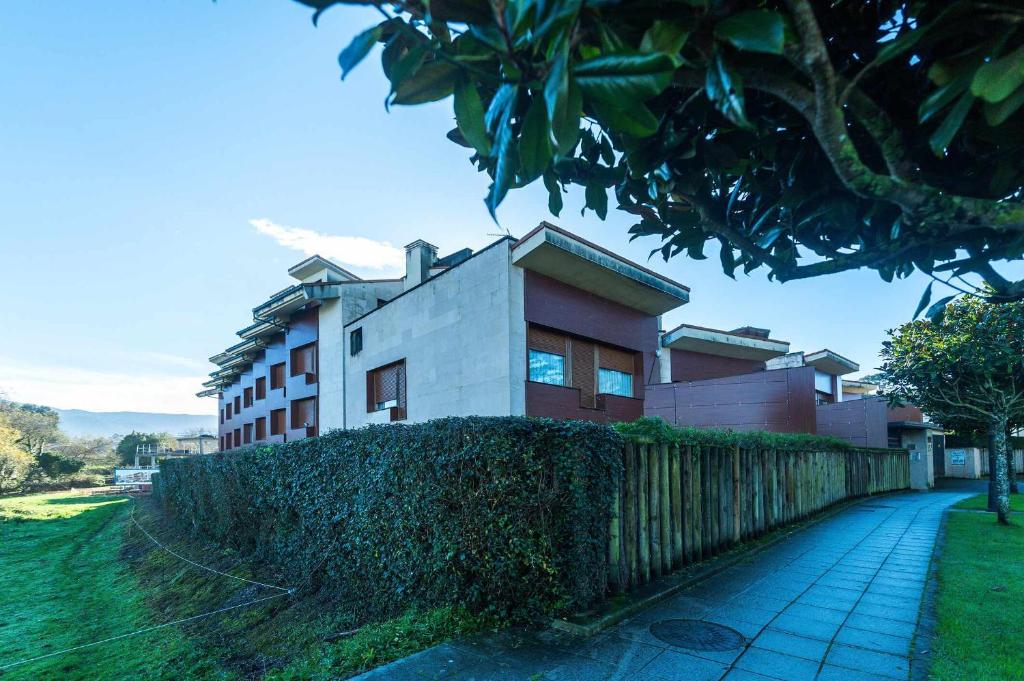 un bâtiment avec une clôture devant lui dans l'établissement Apartamento Mirador Playa de Barro, à Barro de Llanes