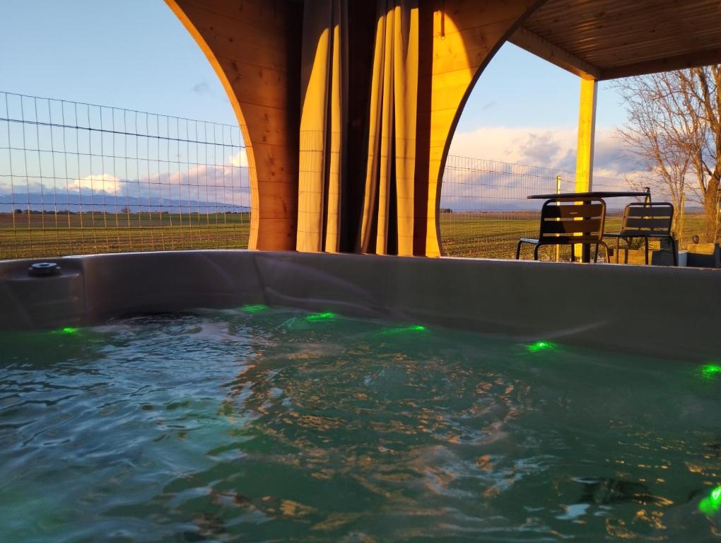 a hot tub with a view of a table and chairs at Le Spa des lavandes in Valensole