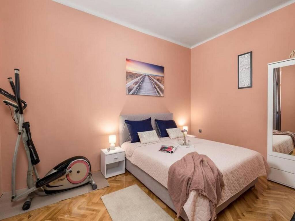 a bedroom with a bed and a treadmill at Apartman KARESA -Rijeka in Rijeka