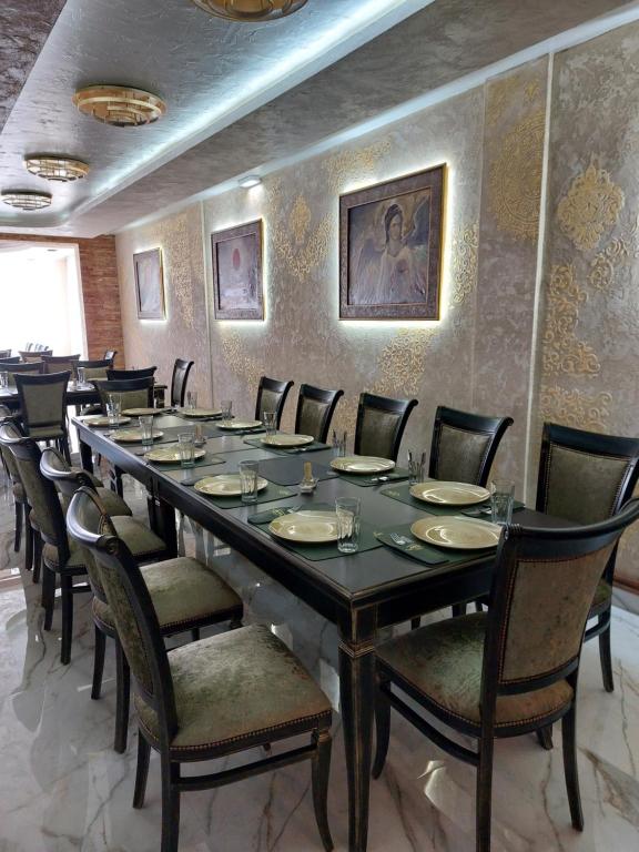 JOKSIM Rooms&Restaurant في Kuršumlija: غرفة طعام كبيرة مع طاولة طويلة وكراسي