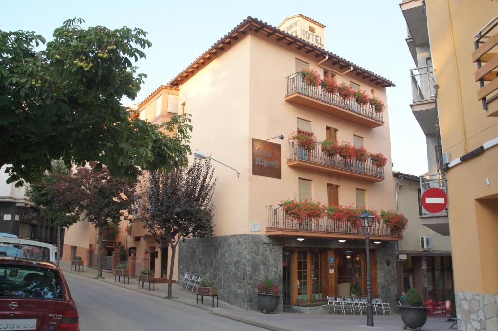 un edificio con flores en los balcones de una calle en Hotel Ripoll, en Sant Hilari Sacalm