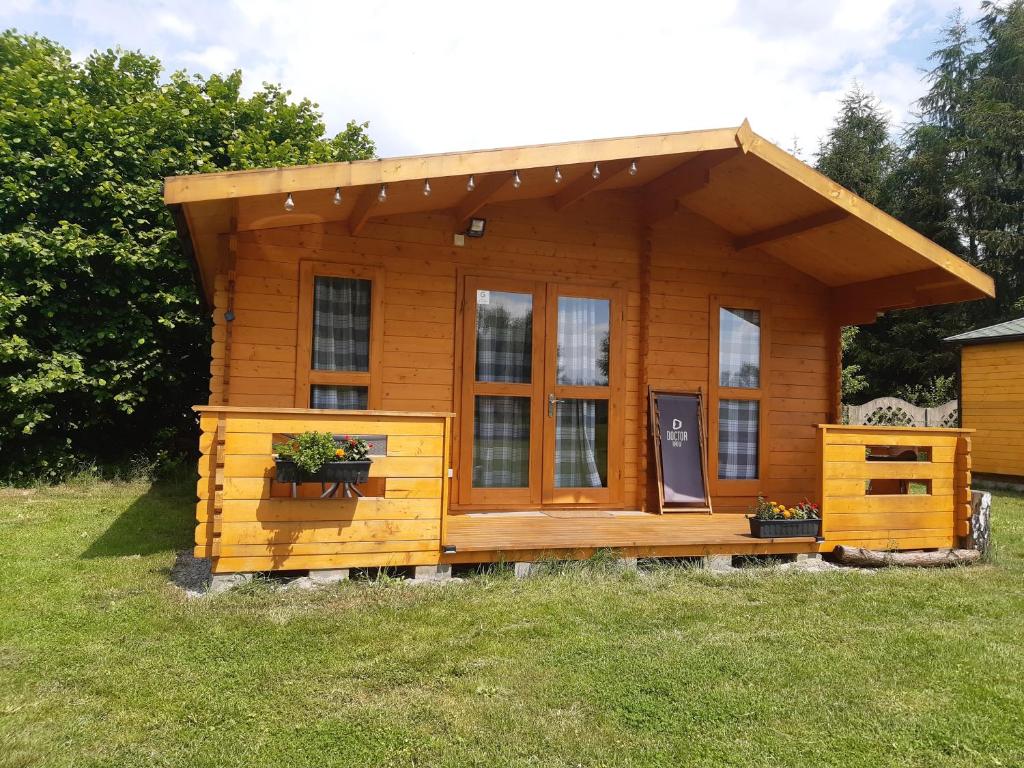 a small wooden cabin in a grass field at Leśnisko in Niegowa