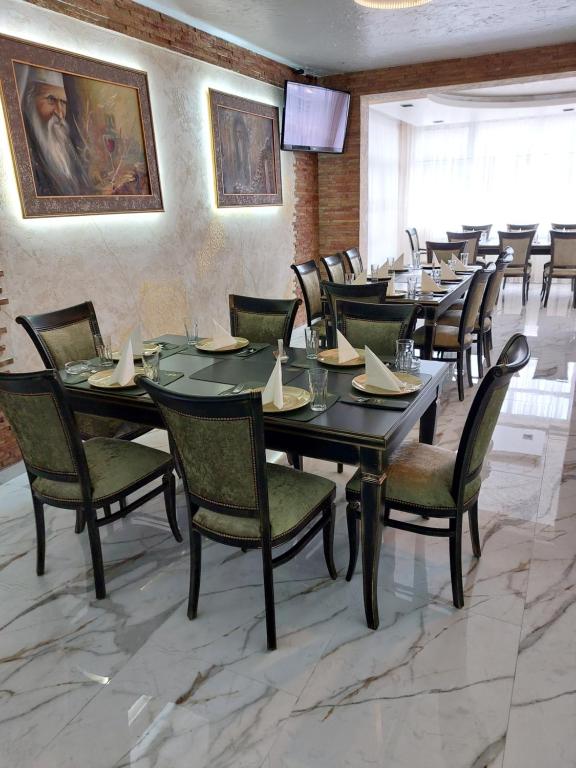 un comedor con una mesa larga y sillas en JOKSIM Rooms&Restaurant, en Kuršumlija