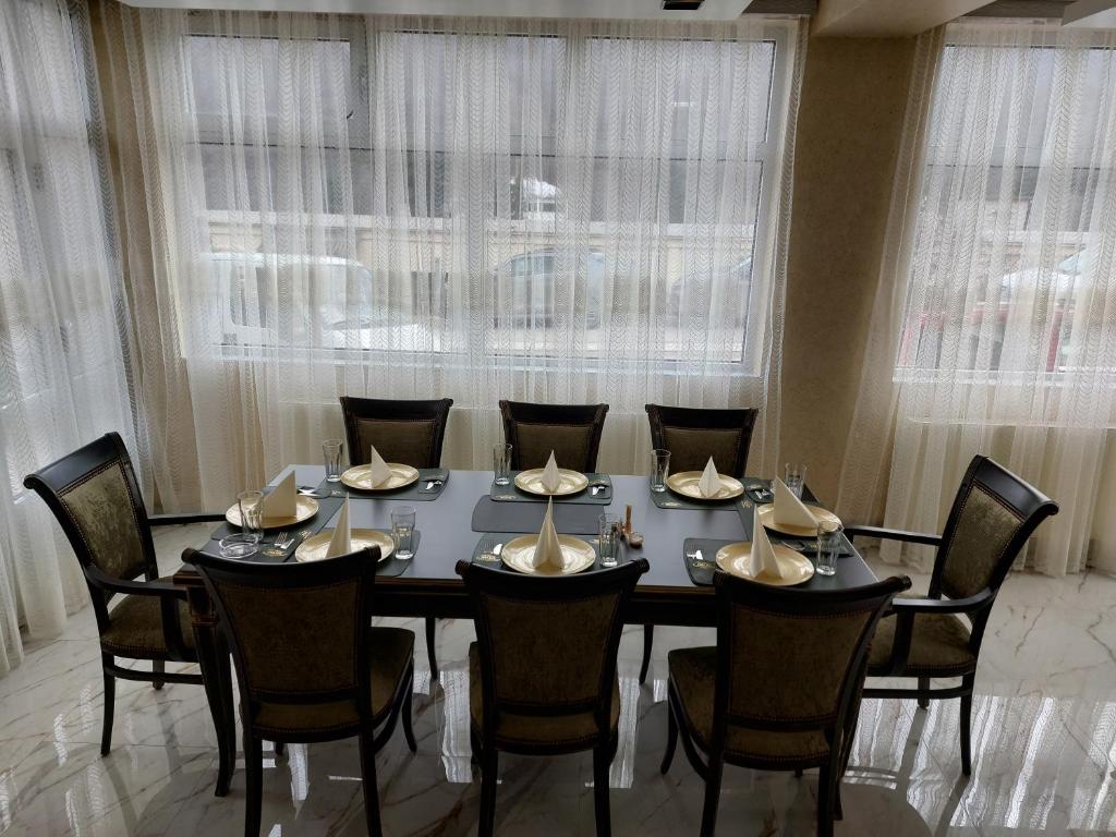 JOKSIM Rooms&Restaurant في Kuršumlija: غرفة طعام مع طاولة وكراسي