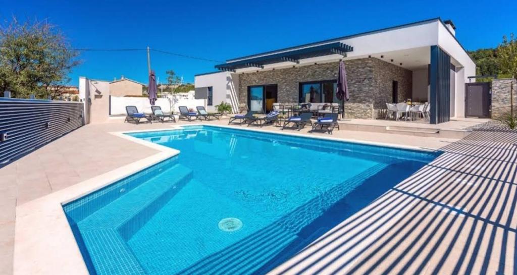 Šestanovac的住宿－"Casa Mia" Luxury villa with heated swimming pool with jacuzzi，房屋前的游泳池