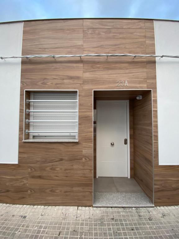 un edificio de madera con puerta y ventana en APARTAMENTOS PASCUAL, en El Cuervo