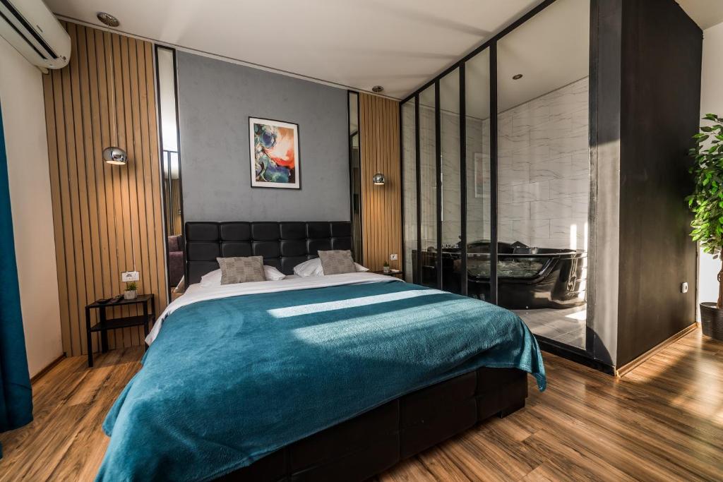 een slaapkamer met een groot bed en een badkamer bij Marcel Apartments in Belgrado