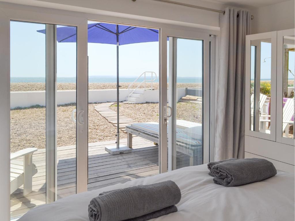 a bedroom with a bed and a view of the beach at Salty Lodge in South Hayling