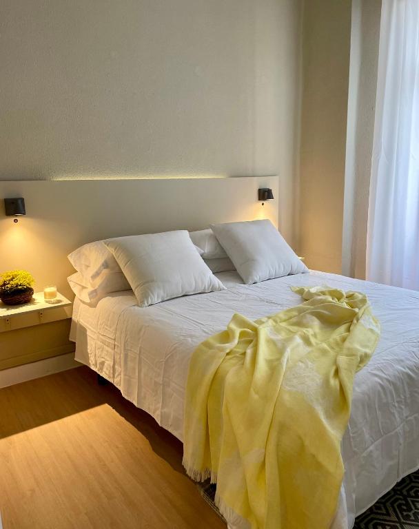 a bed with white sheets and pillows in a bedroom at Apartamentos Concepcion Centro in Albacete