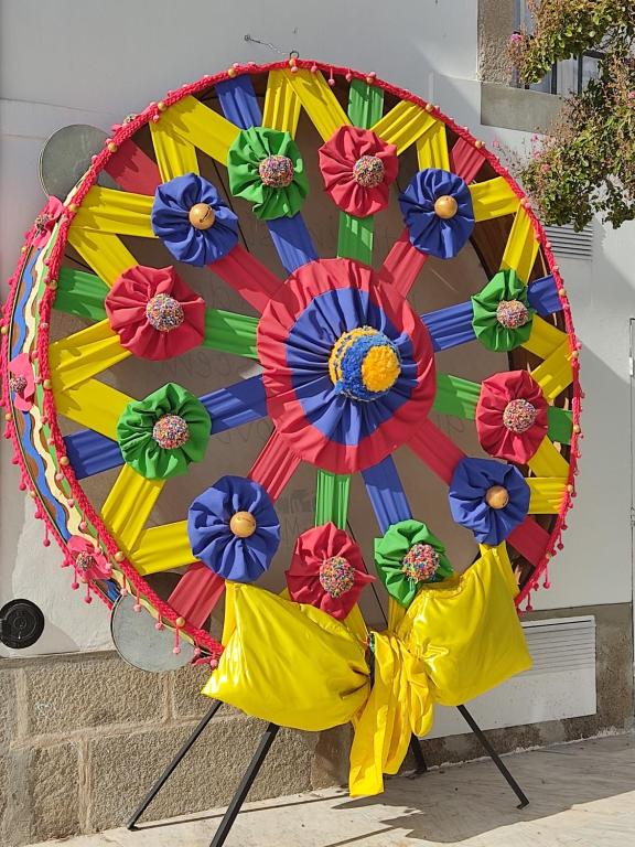 a colorful umbrella with flowers on a wall at Casa Benlindha in Degolados