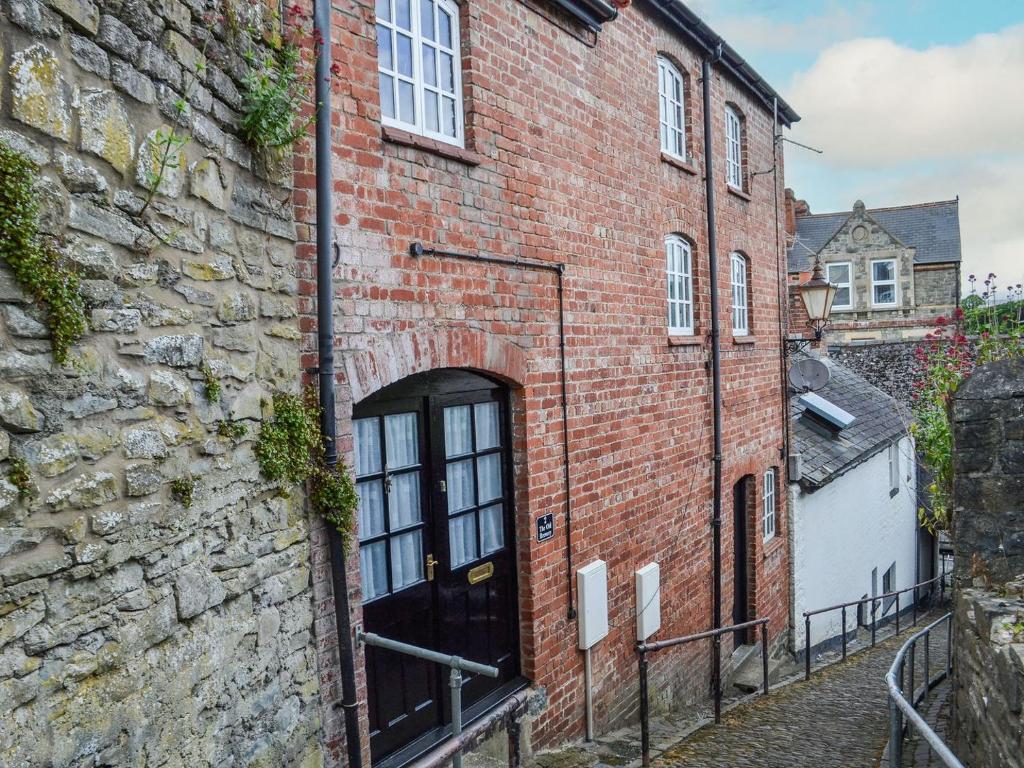 an old brick building with a door on a street at The Old Brewery in Builth Wells