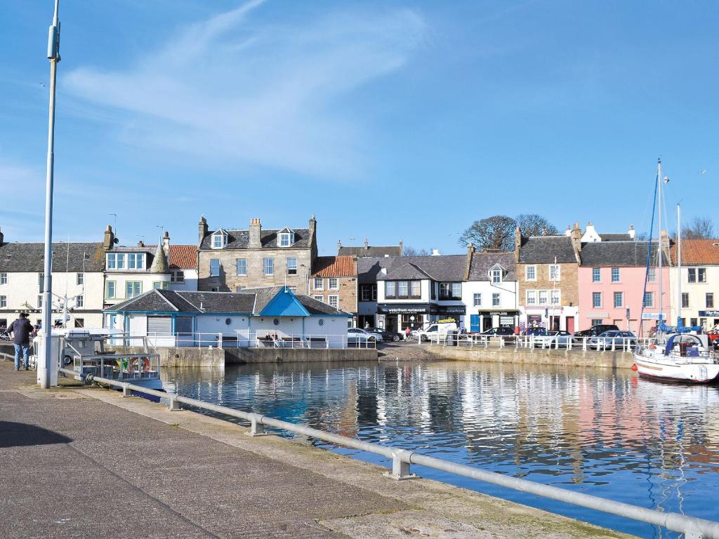 a town with a marina with a boat in the water at Harbourside Apartment in Anstruther