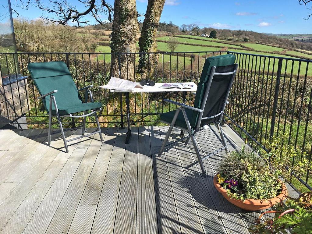 two chairs and a table on a wooden deck at The Platt in Dunterton