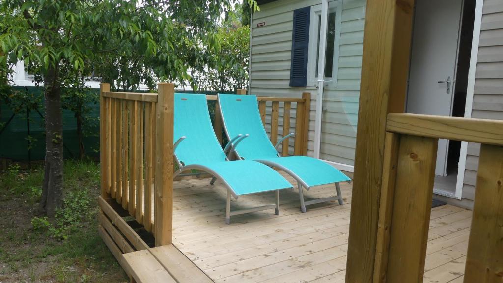 een paar blauwe stoelen op een terras bij camping domaine des iscles in La Roque-dʼAnthéron