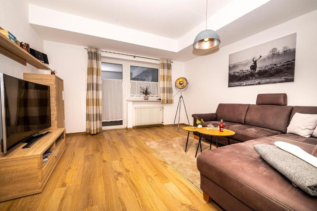 sala de estar con sofá y TV en Ferienwohnung Kircher, en Obermaiselstein