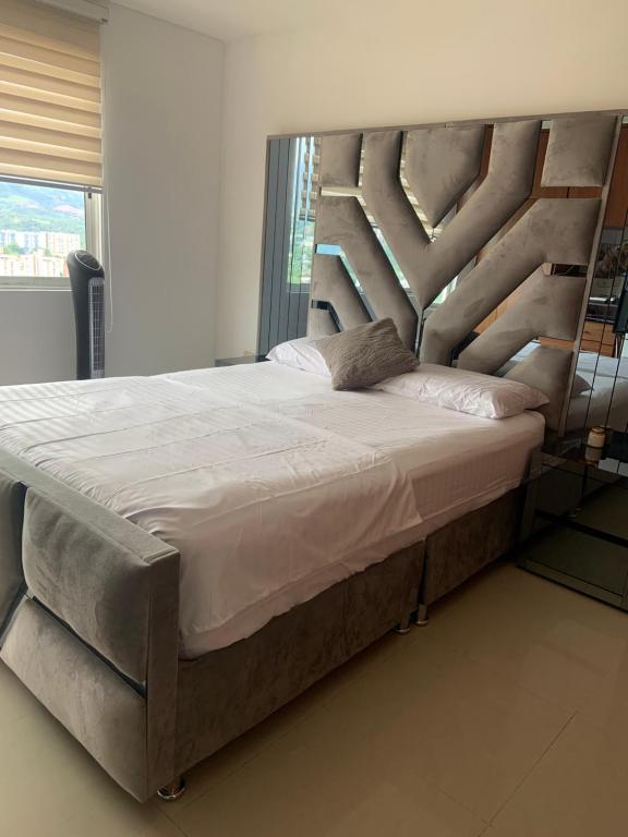 a bedroom with a large bed with a metal headboard at Habitaciones vista azul campestre-diagonal a la Foscal in Floridablanca