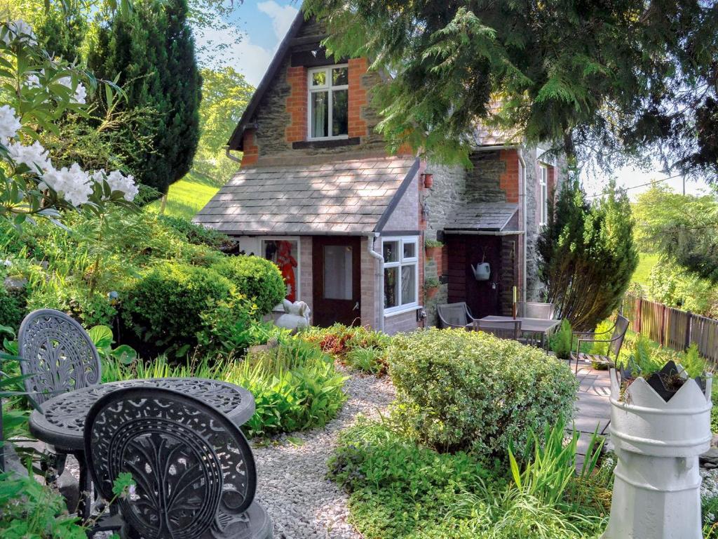 a garden with two benches in front of a house at Colomendy Lodge in Corwen