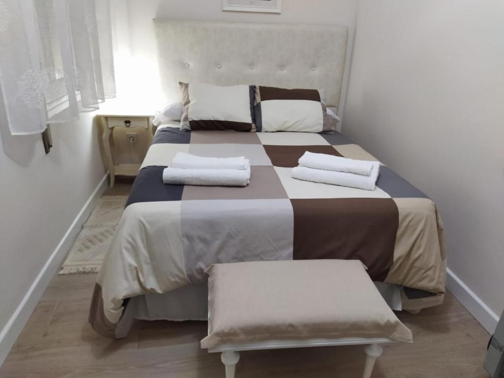 a bedroom with a bed with two white towels on it at Apartamento El Nido in La Guardia