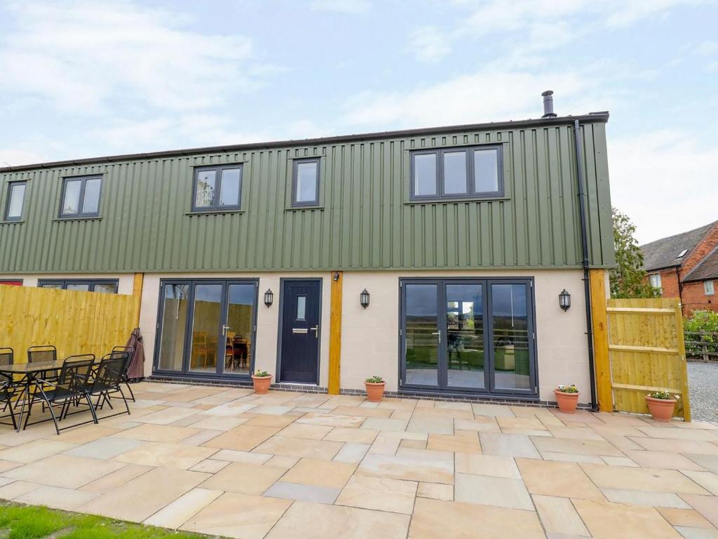 a house with a green roof and a patio at Woodland View - Ukc3893 in Coton in the Elms