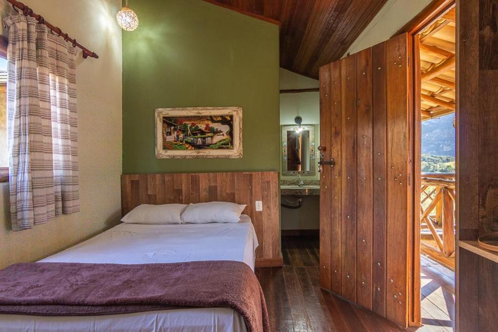 a small bedroom with a bed and a bathroom at Pousada Lapralapa in Santana do Riacho