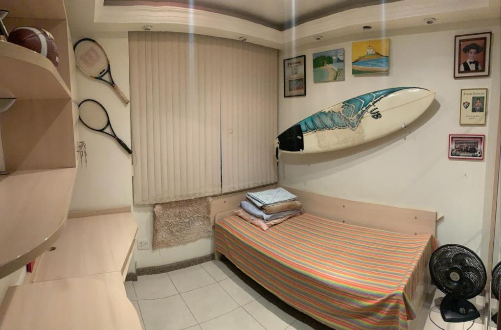 Habitación pequeña con tabla de surf en la pared en Apto Niterói aluga-se 1 quarto en Niterói