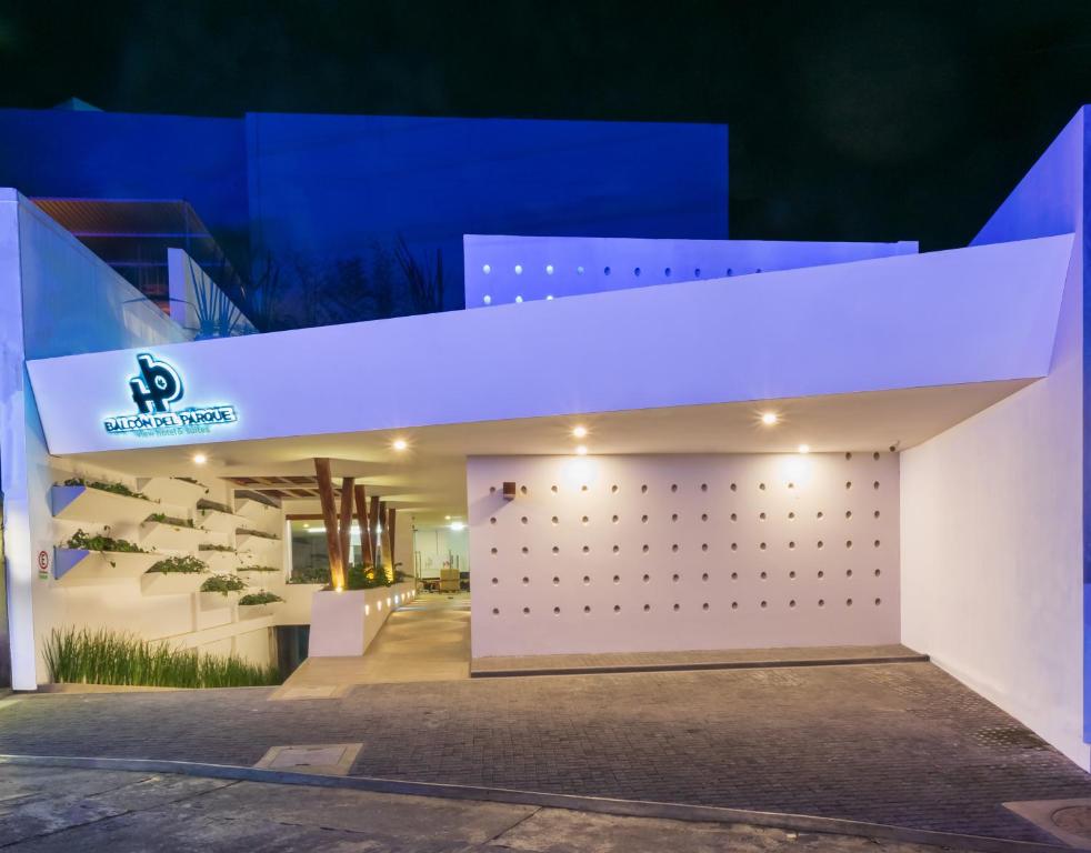 Hotel Balcón del Parque في خالابا: مبنى مضاء بالليل بواجهة بيضاء