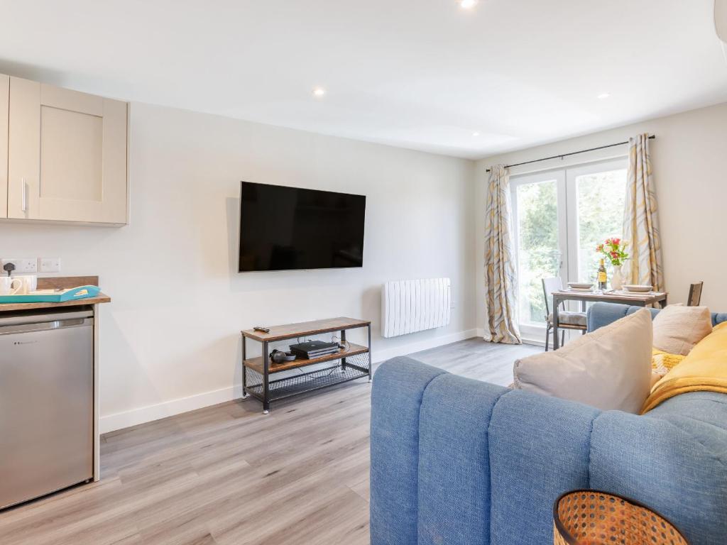 uma sala de estar com um sofá azul e uma cozinha em Kingsleys Lodge em Barnstaple