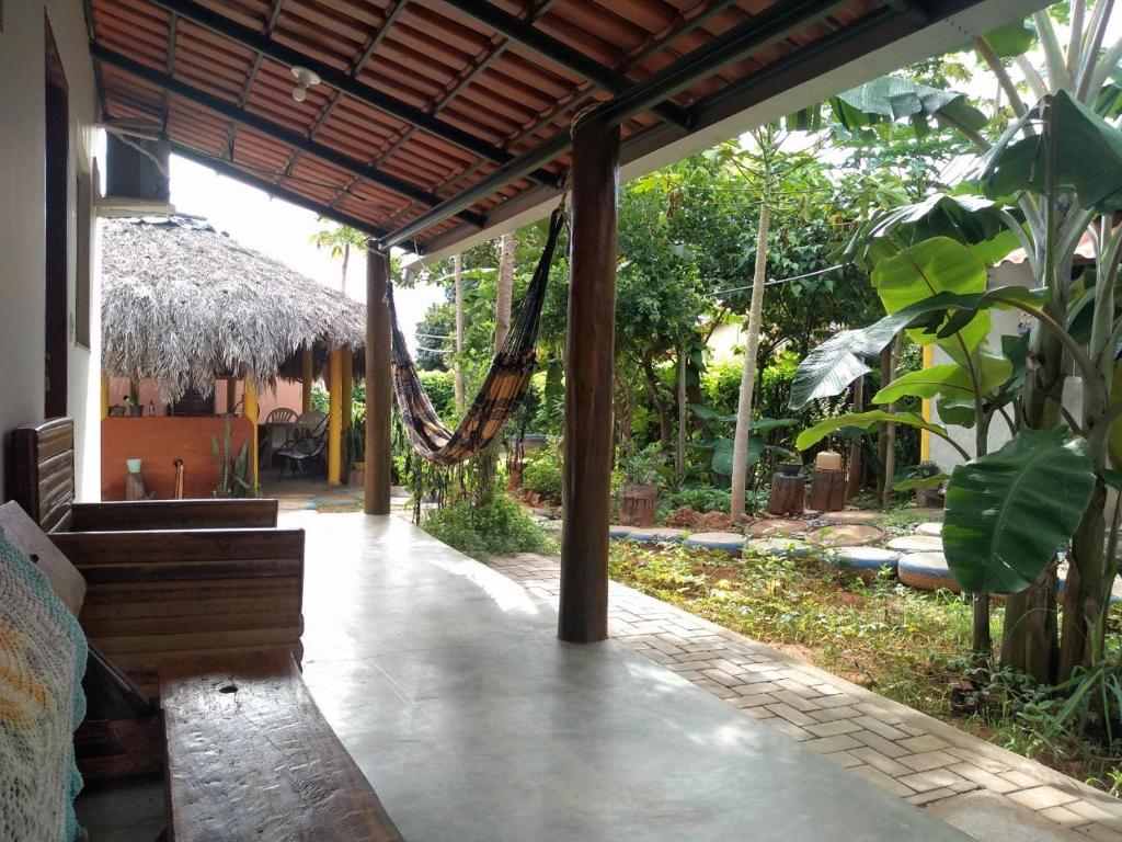 a porch of a house with a bench and a hammock at Pousada Canela de Ema in Mateiros