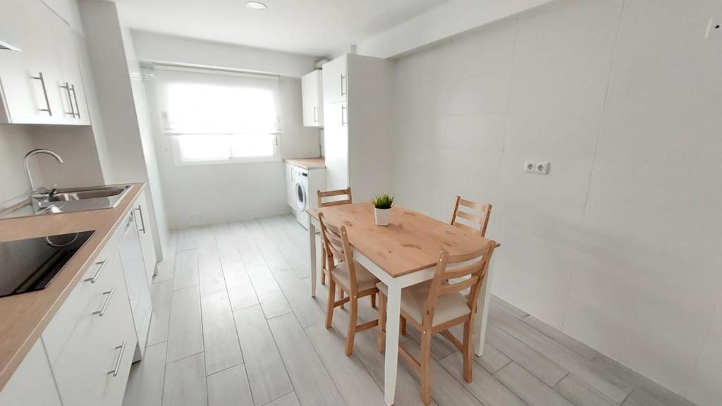 - une cuisine avec une table et des chaises en bois dans la chambre dans l'établissement PISABEL, à Sanlúcar de Barrameda