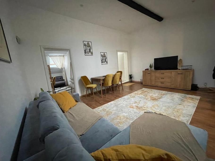 a living room with a blue couch and a table at Apartament la casa in Timişoara