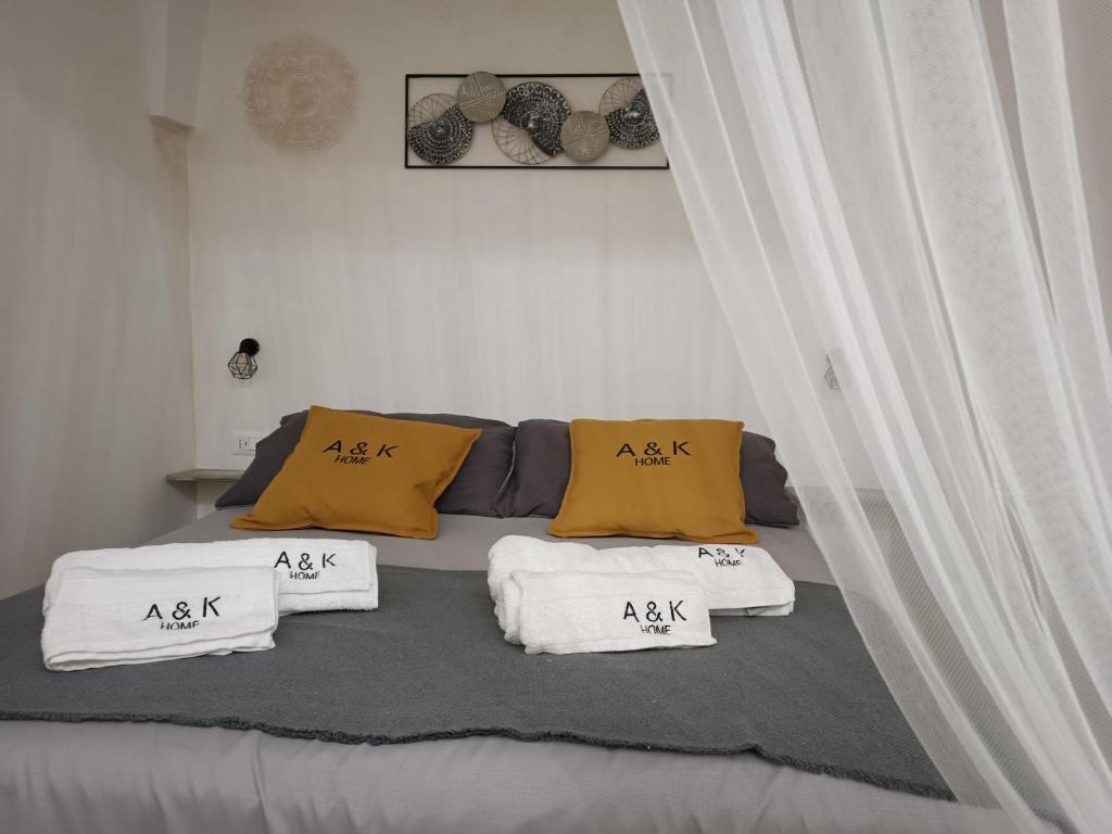 Una cama con almohadas amarillas y blancas. en A&K HOME, en Ceglie Messapica