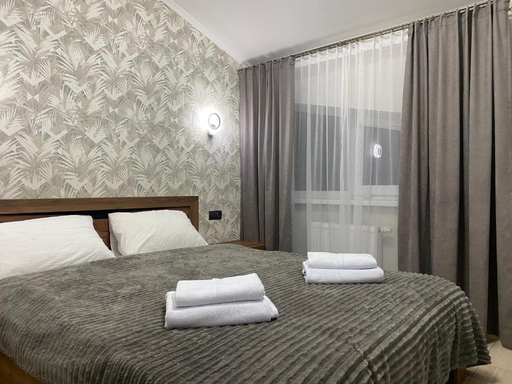 a bedroom with a bed with two towels on it at Готель «У Батька» in Truskavets