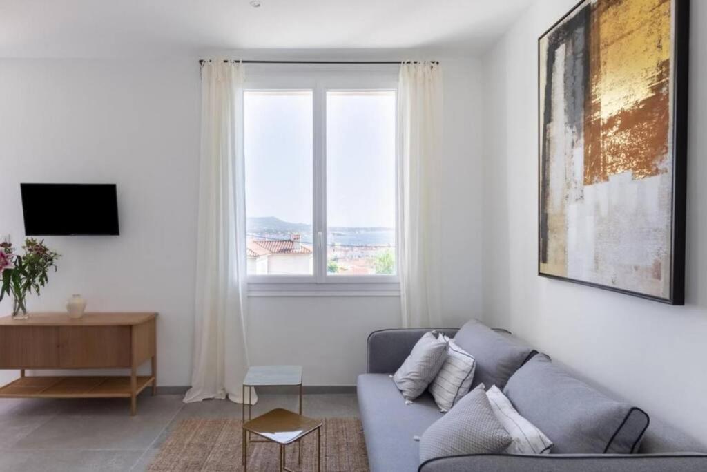 a living room with a couch and a window at Belle vue sur mer, très près du port de Sanary in Sanary-sur-Mer