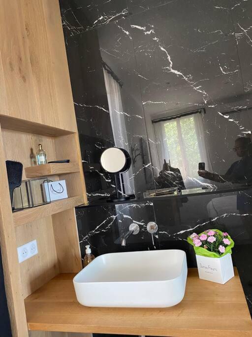 a bathroom with a white sink and a black wall at Belle vue sur mer, très près du port de Sanary in Sanary-sur-Mer